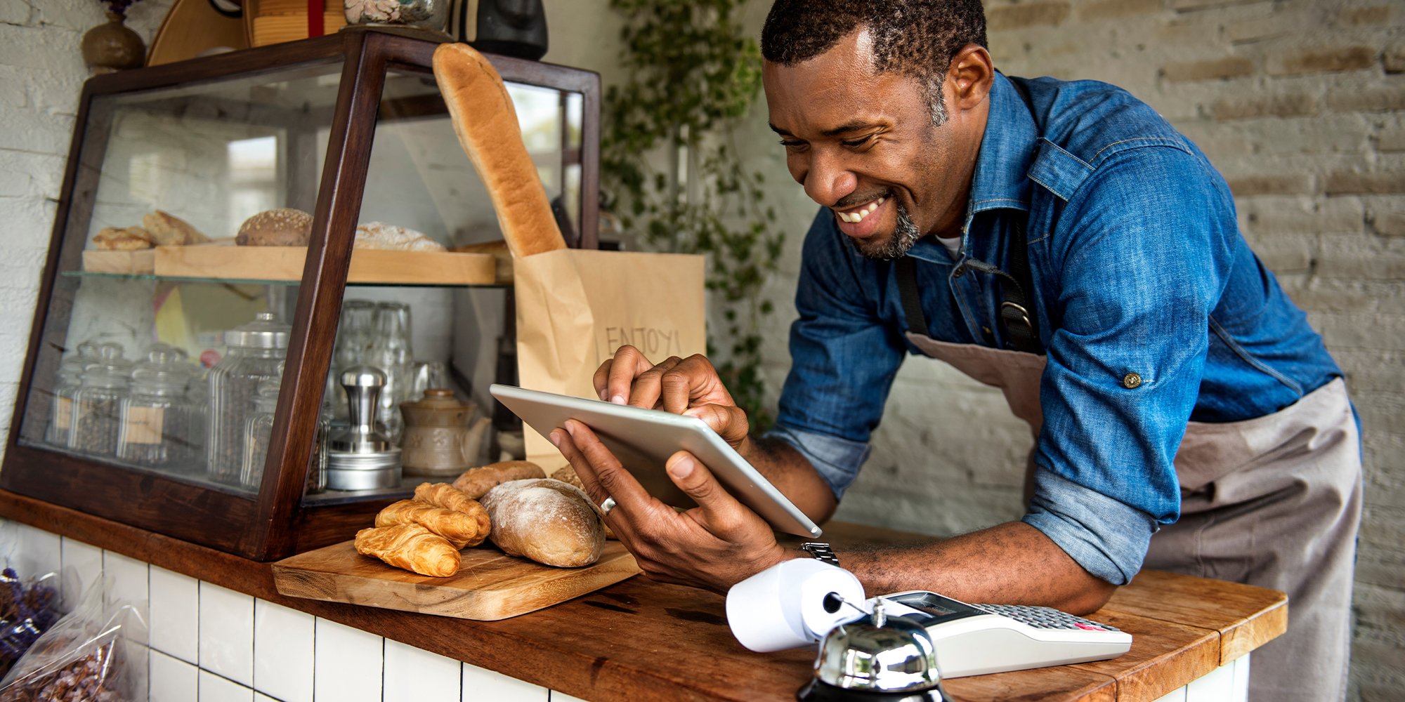 Man using devices for online business order at his bakery.