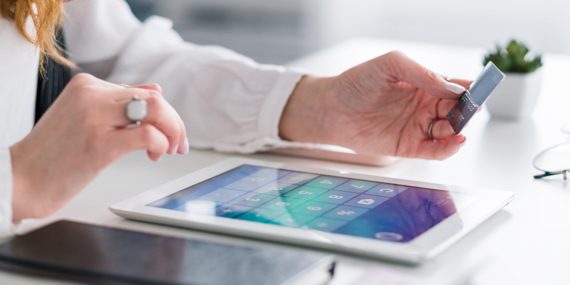 Close up of a person typing in credit card payment information on a tablet.