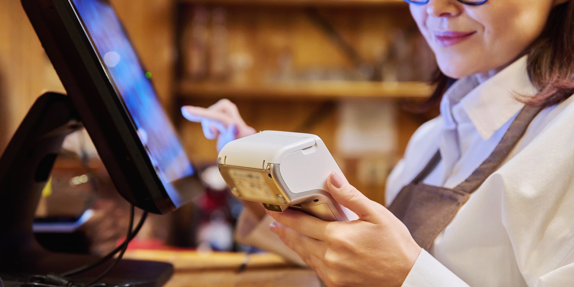 Manager of restaurant holding a wireless payment terminal.